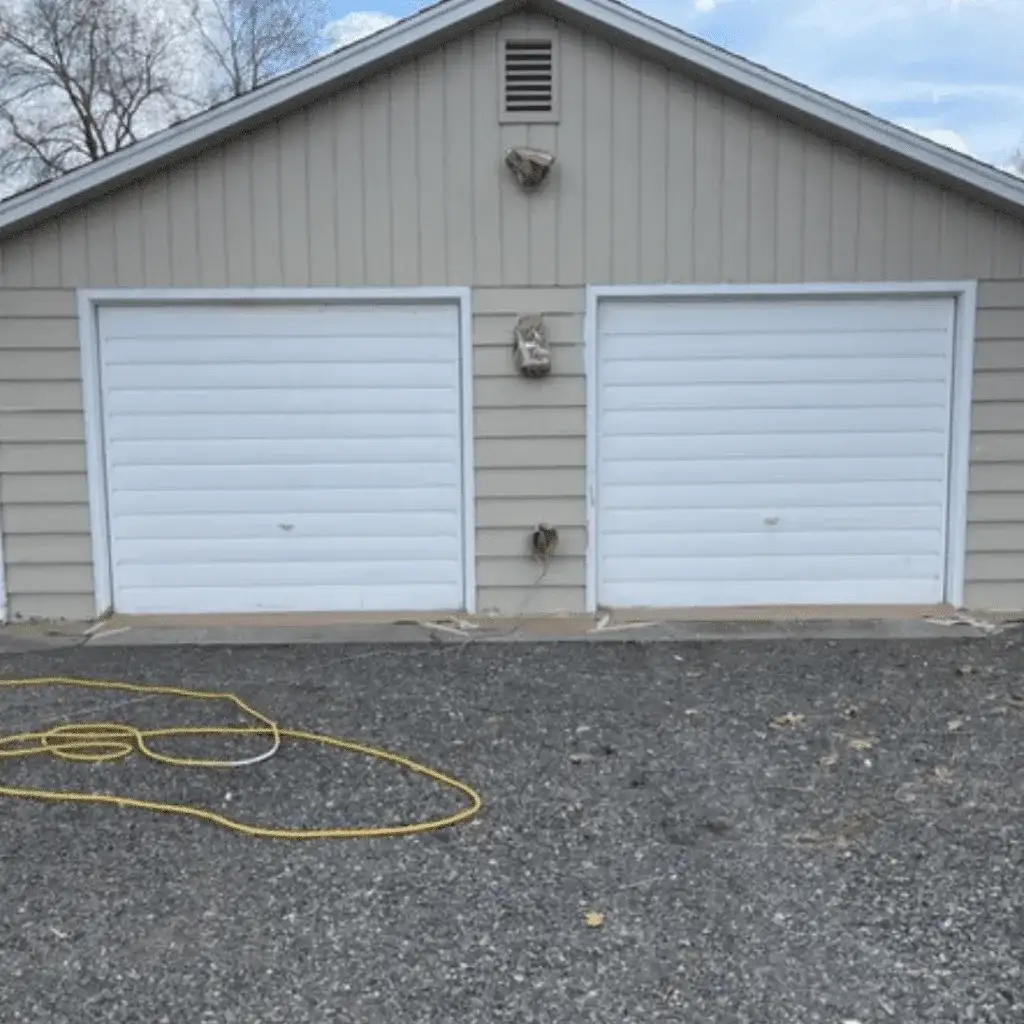 Before: a tan detached garage with two white doors