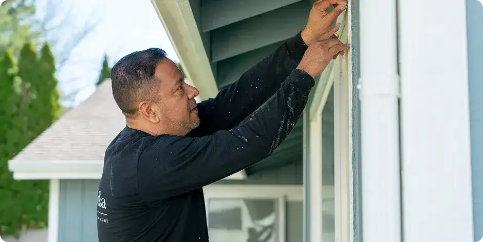 Casa Vida painter working on window trim
