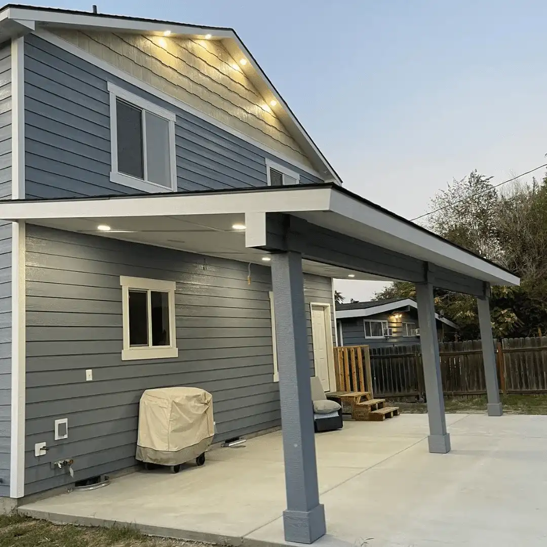 Slate-blue two-story home with white trim and a covered patio with painted posts